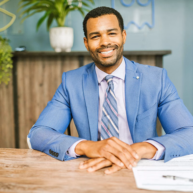 Man Sitting at Table and Smiling